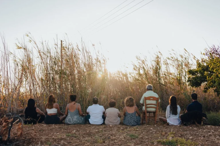 People meditating while watching the sun set